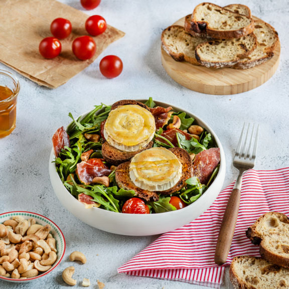 Salade gourmande de chèvre chaud, tomates, roquette et jambon cru