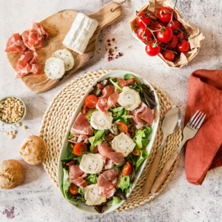 Salade de mesclun, tomates, coppa et bûche de chèvre Poivres et Baies